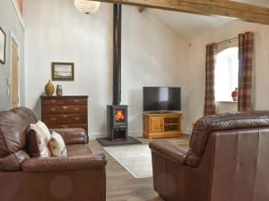 a living room with a couch and a wood stove at Apple Tree Barn- Uk40791 in Church Minshull