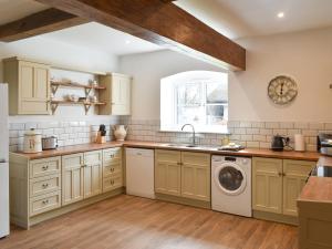 a kitchen with a sink and a washing machine at Apple Tree Barn- Uk40791 in Church Minshull