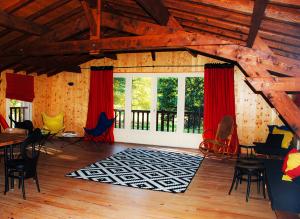 sala de estar con cortinas rojas, mesa y sillas en Laroche, en Barbaste