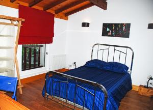 1 dormitorio con cama con sábanas azules y ventana en Laroche, en Barbaste