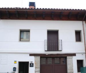 Edificio blanco con puerta roja y balcón en ALTAR SUITES Caño Badillo en León