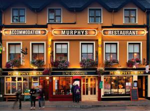 a building with people walking in front of it at Murphys of Killarney in Killarney