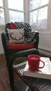 a wicker chair with a red mug on a table at Colborne Bed and Breakfast in Goderich