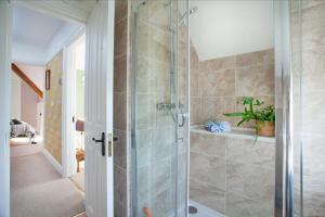 a bathroom with a shower with a glass door at The Roost in Budleigh Salterton
