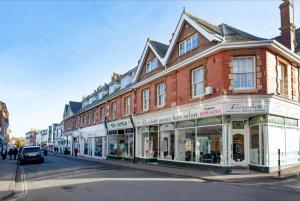 un edificio in una strada con un'auto parcheggiata di fronte di The Roost a Budleigh Salterton