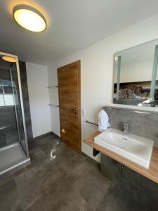 een badkamer met een wastafel en een spiegel bij Landgasthaus zum Kreuz GbR in Isny im Allgäu