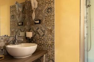 een badkamer met een witte wastafel en een tegelmuur bij Central City Genova in Genua