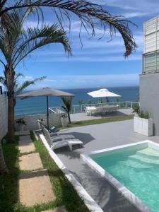 a swimming pool with a view of the ocean at The Villa Umdloti in Umdloti