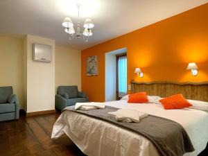 a bedroom with a large bed and two chairs at CASA RURAL ERVITENA in Oteiza