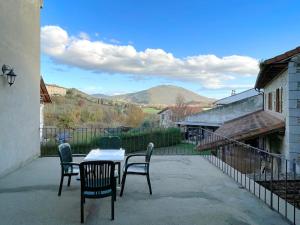 a table and chairs on a patio with mountains in the background at CASA RURAL ERVITENA in Oteiza