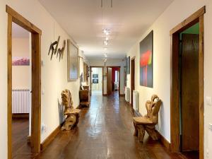 a hallway with chairs and paintings on the walls at CASA RURAL ERVITENA in Oteiza