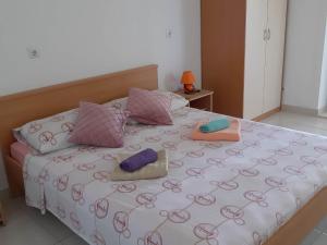 a bed with three pillows on top of it at Apartments Franka Saplunara in Saplunara