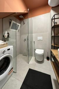 uma casa de banho com um chuveiro e uma máquina de lavar roupa em Studio in Tirana em Tirana