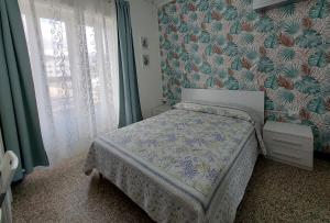 a bedroom with a bed with a floral wallpaper at Villa La Lanterna in Pietra Ligure