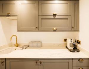 a kitchen with white cabinets and a sink at New - Bright - Fresh - with Parking in Bath