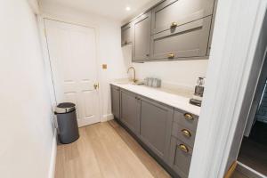 a kitchen with gray cabinets and a trash can at New - Bright - Fresh - with Parking in Bath