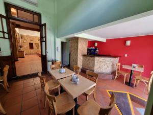 un ristorante con tavoli, sedie e una parete rossa di Refugio del Inca a Salta