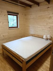 a bedroom with a bed in a wooden room at Dom Sosnowy in Szczytno