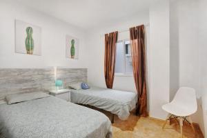 Un dormitorio con 2 camas y una silla. en 3 bedroom apartment near Sta Cruz, en Santa Cruz de Tenerife