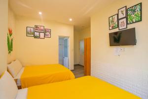 a room with two beds and a flat screen tv at Big Home Dalat in Da Lat