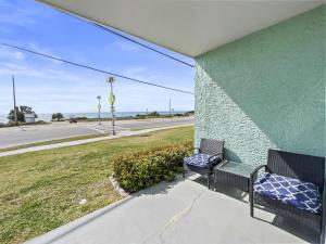 two benches sitting on a porch with a view of a street at Emerald Shores #1001 Condo in Panama City Beach