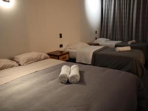 Habitación de hotel con 2 camas y toallas. en Hostal Litoral, en Iquique