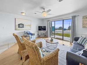 a living room with a couch and chairs and a tv at Emerald Shores #1001 Condo in Panama City Beach