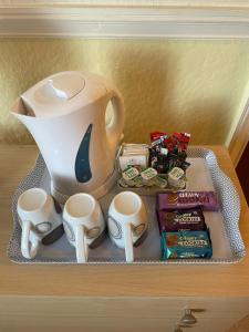 a table with a tea pot and some snacks at Nevele in Blackpool