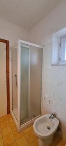 a bathroom with a shower and a toilet and a sink at Il Poggiolo di Levante - Piscina e Ombrellone spiaggia prima fila incluso in Marcelli +16 photos