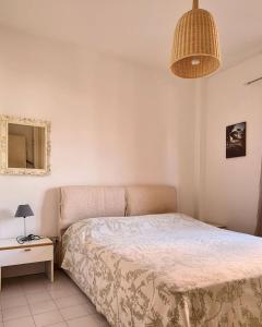 a bedroom with a bed and a table and a lamp at Il Poggiolo di Levante - Piscina e Ombrellone spiaggia prima fila incluso in Marcelli