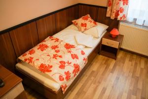 Turistická ubytovňa BUCK** في Tornaľa: سرير صغير في غرفة مع أرضية خشبية