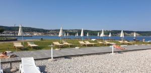 a group of chairs and tables with umbrellas on a beach at Bonaca in Izola