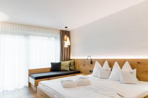 1 dormitorio con 1 cama grande con almohadas blancas en JOAS natur.hotel.b&b, en San Candido