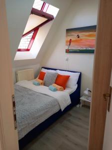 a bedroom with a bed with orange and white pillows at Ena Apartment in Tuzla