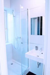 baño blanco con ducha y lavamanos en KOMFORT WILLA+ BIS, en Blizne Łaszczyńskiego