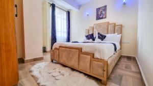 a bedroom with a large bed with blue pillows at Luxury 1Br Apartment with Secure Parking & Lift Nakuru in Nakuru