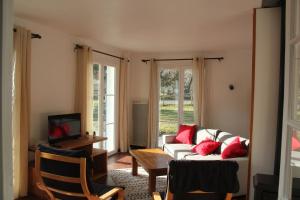 ein Wohnzimmer mit einem Sofa und einem Tisch in der Unterkunft Gite l'Estibère en Val d'Azun in Aucun