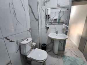 Un baño blanco con inodoro y lavabo. en Sweet Dreams Apartment Sari, en Tirana