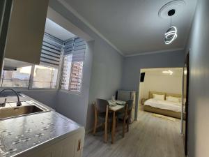 Una cocina con un fregadero y una mesa en una habitación. en Sweet Dreams Apartment Sari, en Tirana