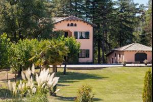 una gran casa blanca con árboles y un patio en La Torre del Dr. Pont. Nature and entertainment. en Sant Boi de Lluçanès