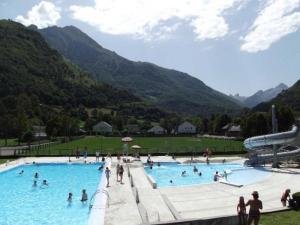 eine Gruppe von Menschen in einem Schwimmbad mit Bergen in der Unterkunft Gite l'Estibère en Val d'Azun in Aucun