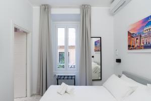 een witte slaapkamer met 2 bedden en een spiegel bij White Home Suite and Rooms in Rome