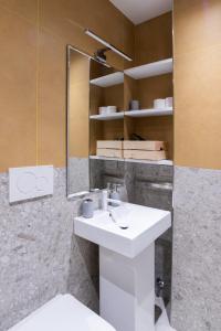 een badkamer met een witte wastafel en een spiegel bij White Home Suite and Rooms in Rome