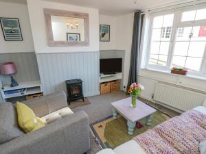 a living room with a couch and a fire place at 1 Tulse Hill Cottages in Ventnor