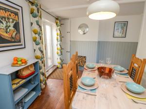 a dining room with a wooden table and chairs at 1 Tulse Hill Cottages in Ventnor