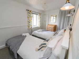 a bedroom with two beds and a window at 1 Tulse Hill Cottages in Ventnor