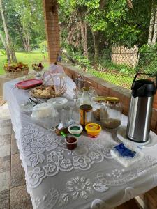 una mesa con un mantel blanco con comida. en Pousada Casa Ferreira, en Pirenópolis