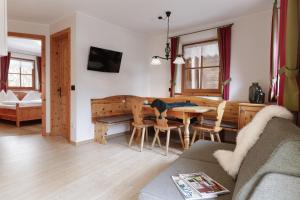 cocina y sala de estar con mesa y sillas en Chalet Winklwiese, en Valdaora