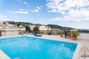 a swimming pool on the roof of a building at Adonis Cannes - Hôtel Thomas in Le Cannet