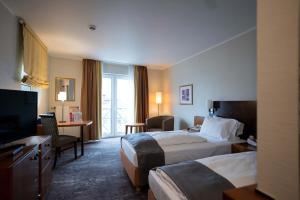 a hotel room with two beds and a television at Hotel Fulda Mitte in Fulda